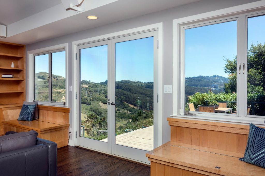 Large windows and glass doors overlooking a landscaped hillside